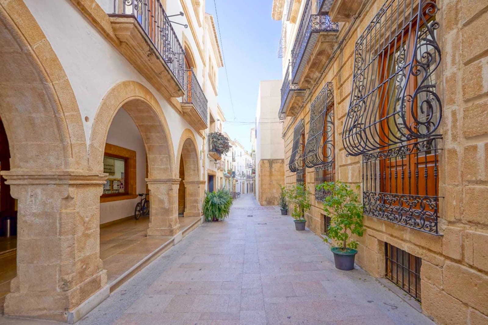 A street in the old town of Jávea, sandstone arches and iron window grilles